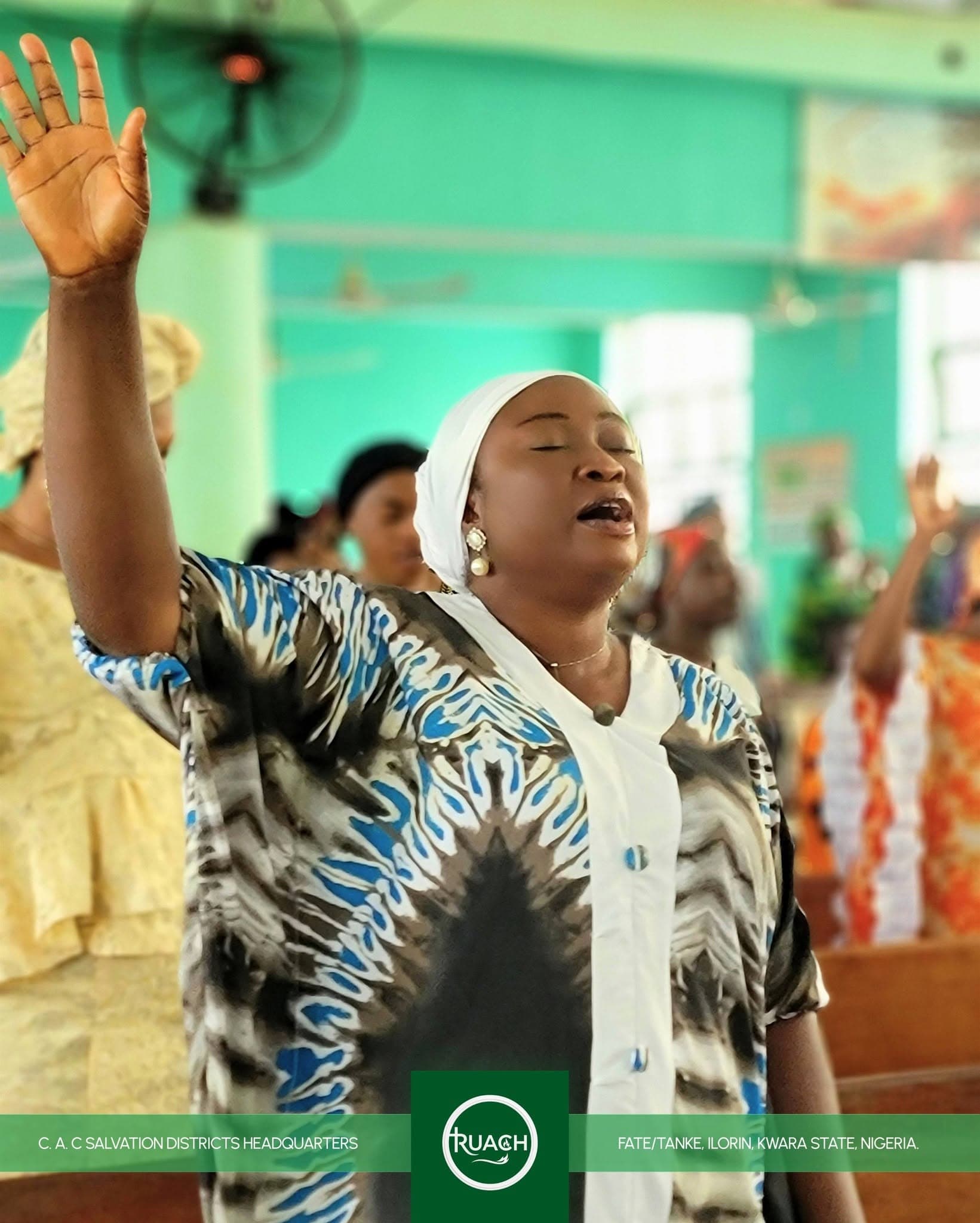 A member of the congregation worshipping with raised hands at C.A.C Salvation Centre, Ilorin